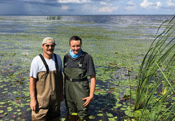 Ms. Megan Reid and Dr. James P. Cuda surrounded by yellow water lilies in Lake George, Volusia Co., FL.