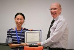 Ya Guo receiving a certificate for her second place award in the postdoctoral poster competition at the Florida Genetics Symposium