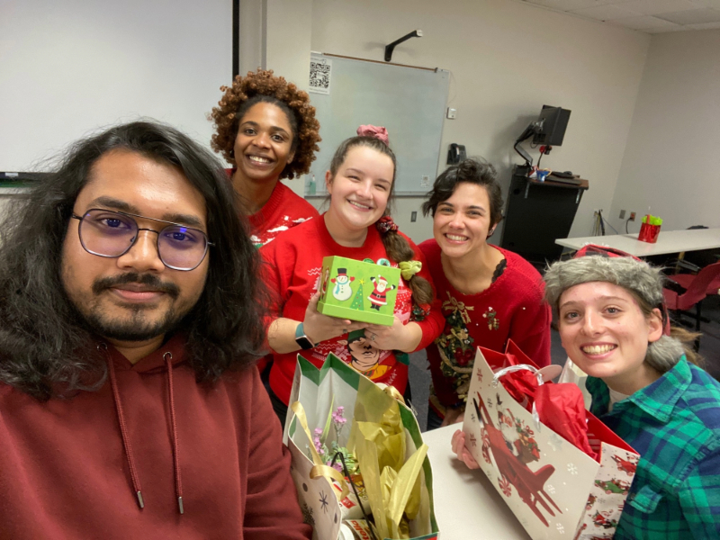 a group of students holding wrapped holiday gifts