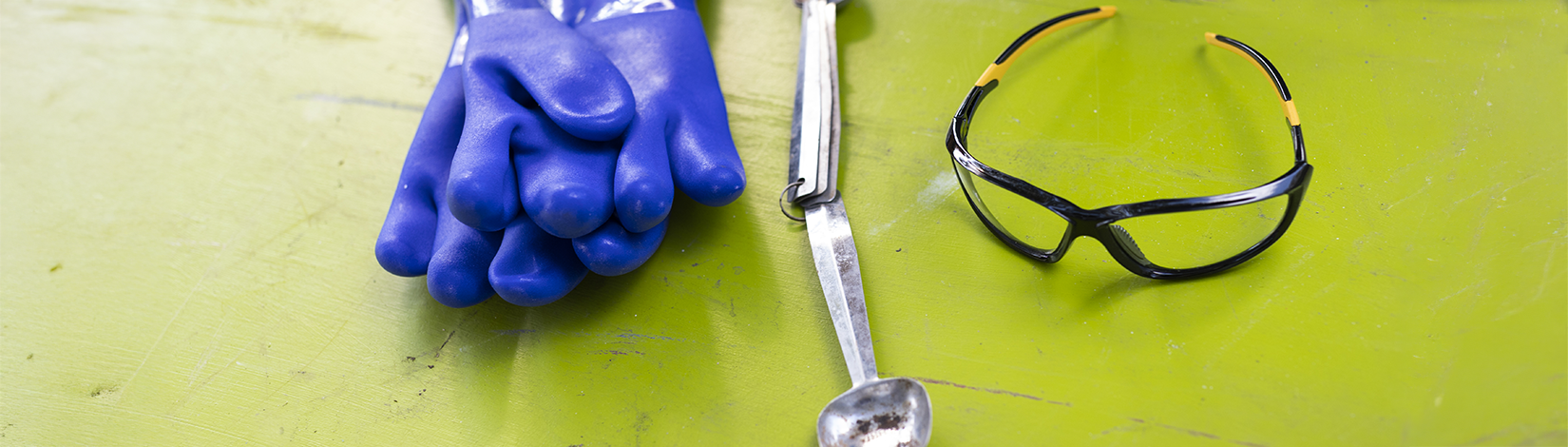 a photo of lab equipment, gloves, goggles, measuring spoons