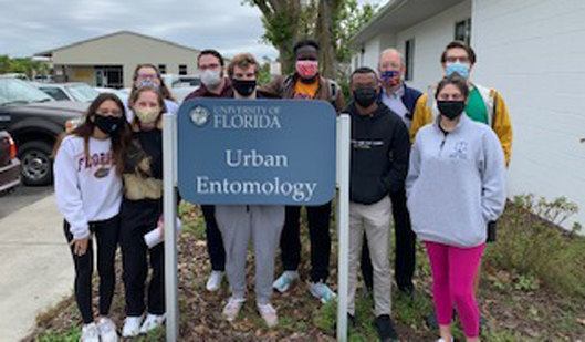 UF Mock Trial team standing with Urban Entomology sign 