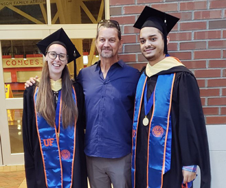 Dr. Johan Desaeger stands with his students Jacqueline Coburn and David Calix Moreira during graduation on August 7th. 