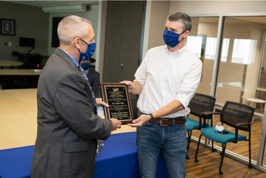 Photo of Nick Place giving Dr. Ellis award. Both men are wearing face masks. 