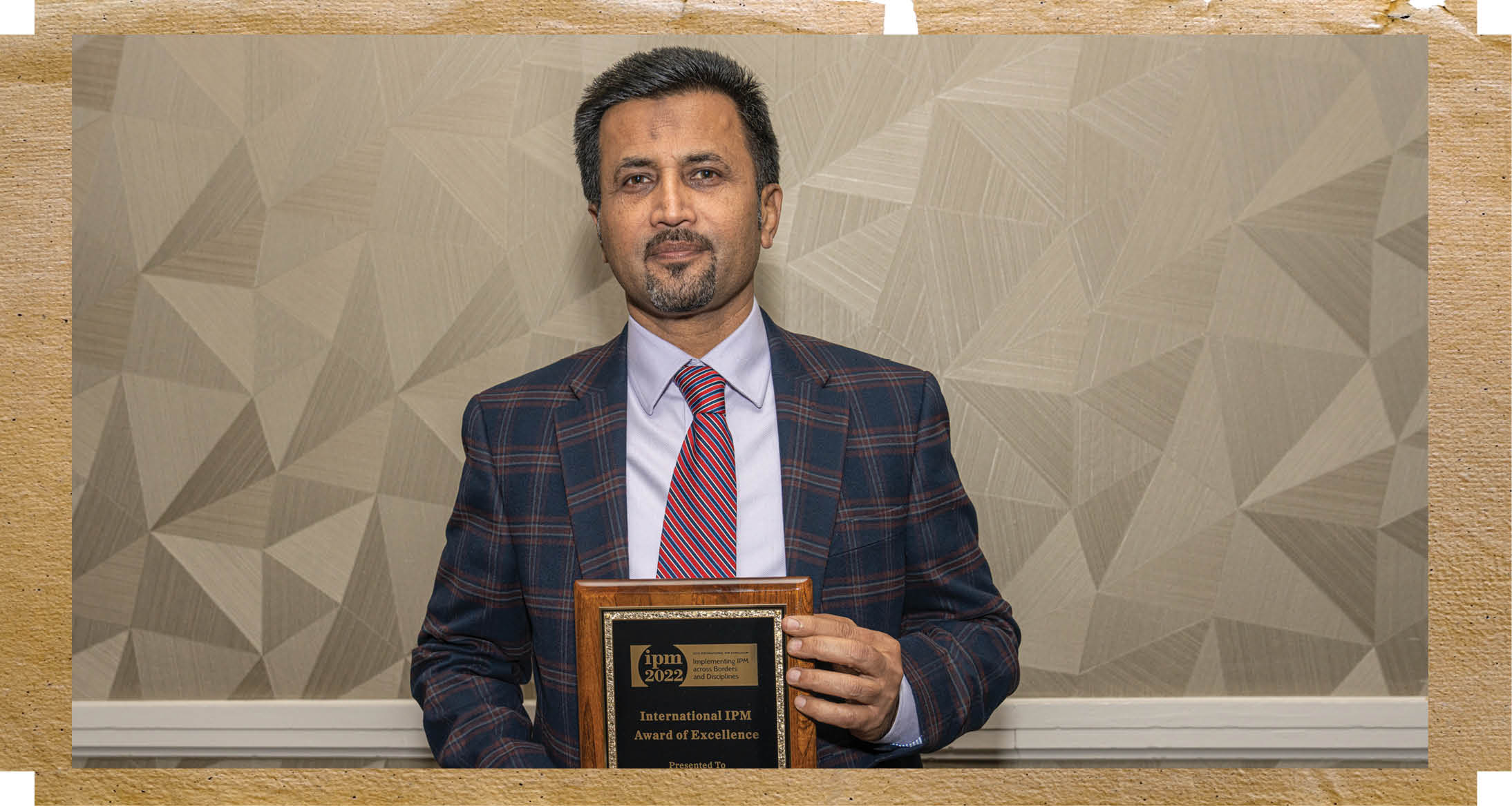 Dr. Qureshi holding his plaque award